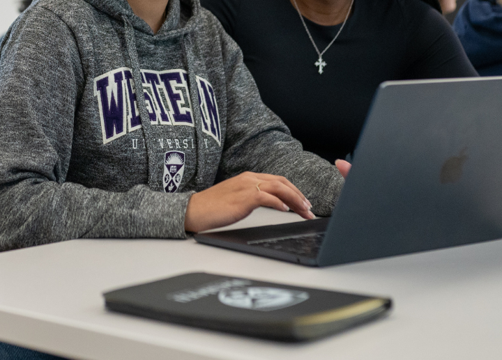 western students working on a laptop