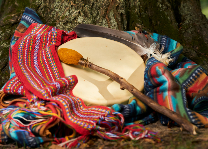 drum and drum stick on a blanket, Métis sash and eagle feather