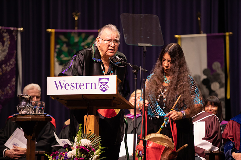 Elder Dan Smoke, giving a speech standing next to Mary Lou Smoke