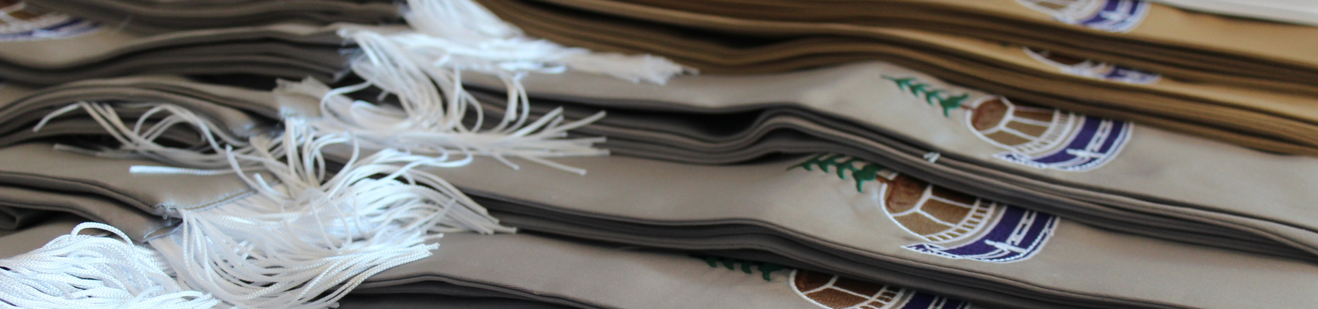 indigenous graduation stoles in grey, gold, and white